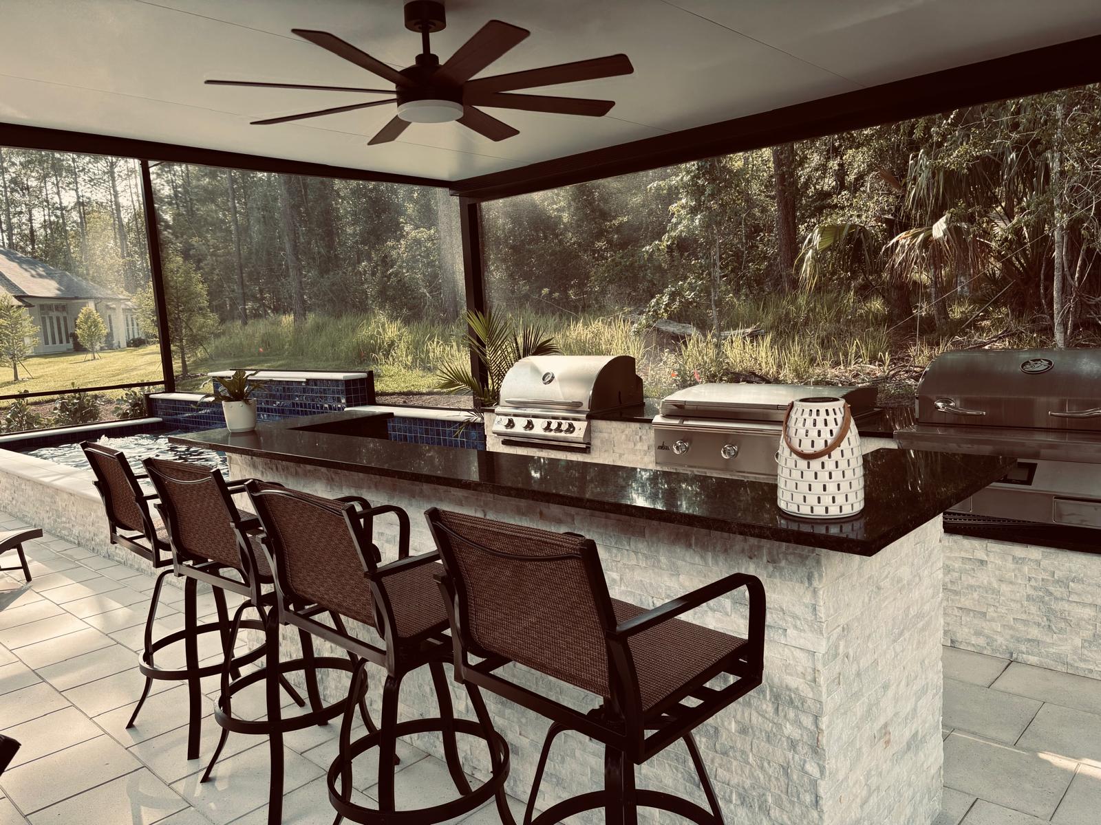 Covered outdoor kitchen with bar seating and grill